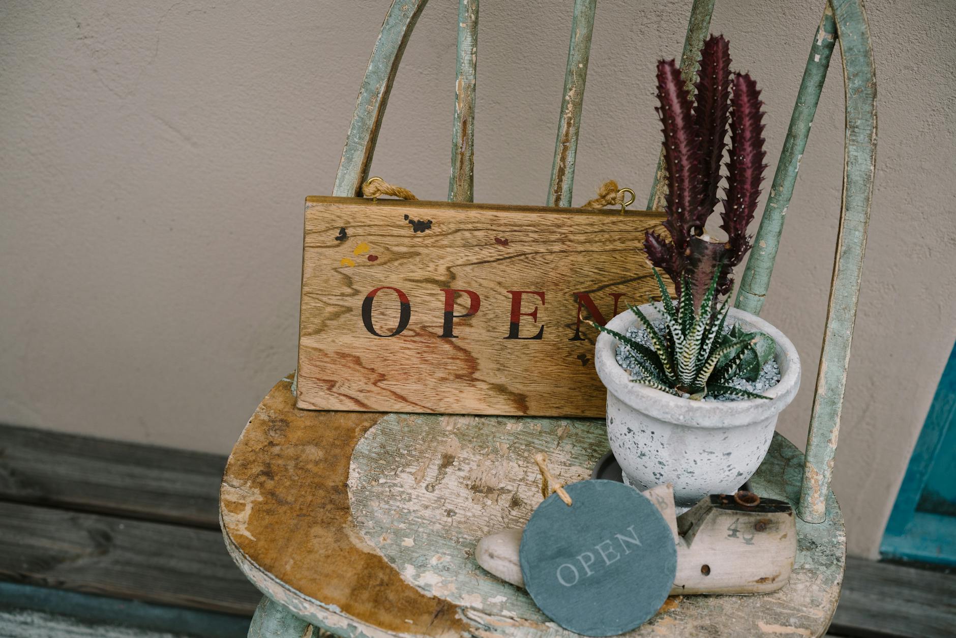 a wooden sign with the word open on it sits on a chair